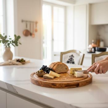 Round olive wood chopping board in kitchen setting