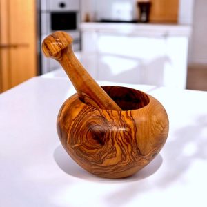 Round olive wood mortar and pestle in a kitchen