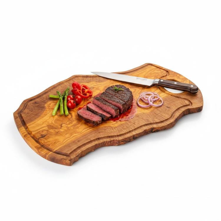 Olive wood chopping board with handle and juice groove serving sliced steak and vegetables