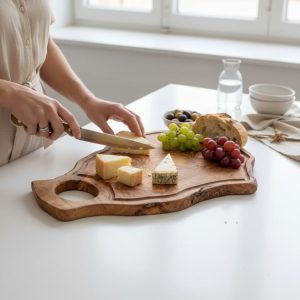Irregular shape olive wood chopping board with handle and groove used for serving cheese and fruit
