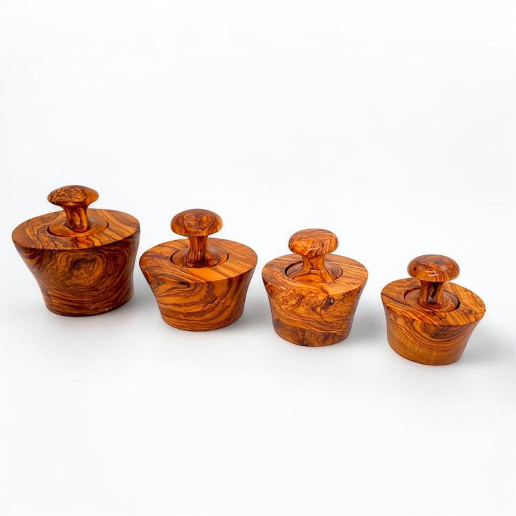 Four olive wood garlic mortar and pestle sets in different sizes showing natural grain variations