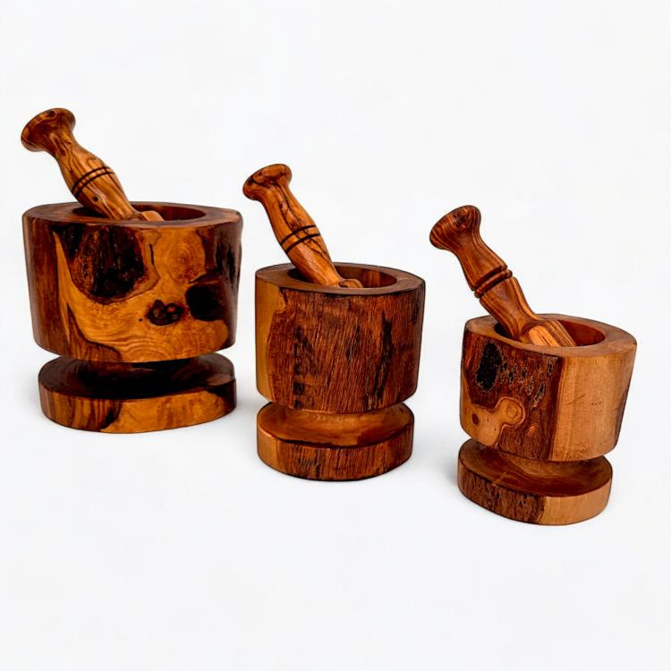 Three olive wood rustic mortar and pestle sets with wooden bases showing different sizes and natural grain patterns